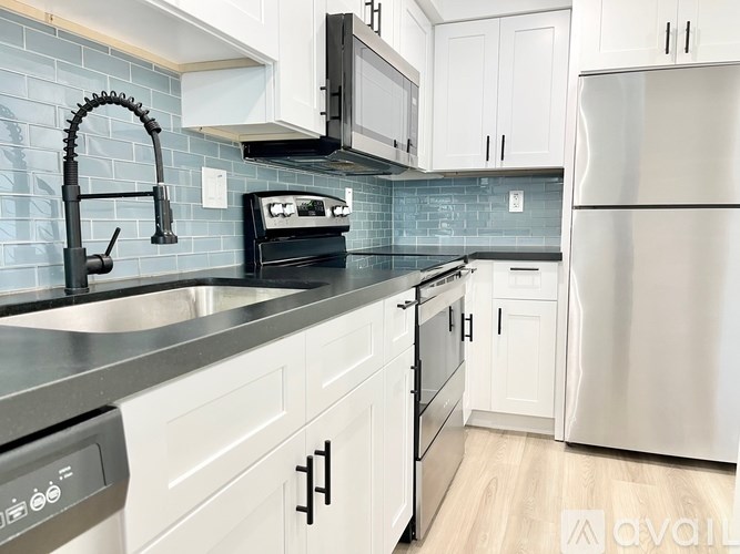 A kitchen with white cabinets and a black oven.