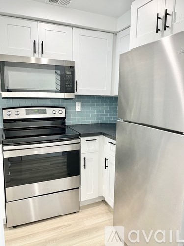 A kitchen with a stainless steel refrigerator, oven, and microwave.