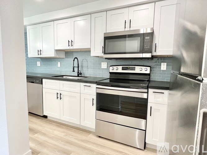 A kitchen with white cabinets and stainless steel appliances.