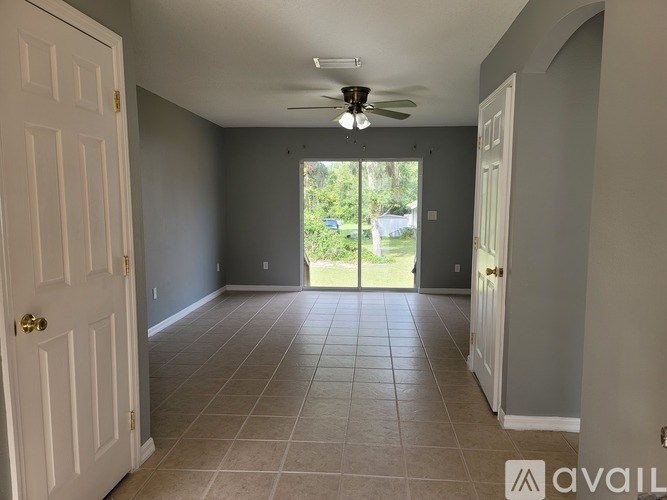 A room with a ceiling fan and tiled floor.