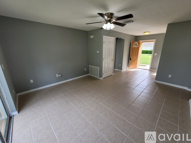 A spacious room with a ceiling fan and tiled flooring.