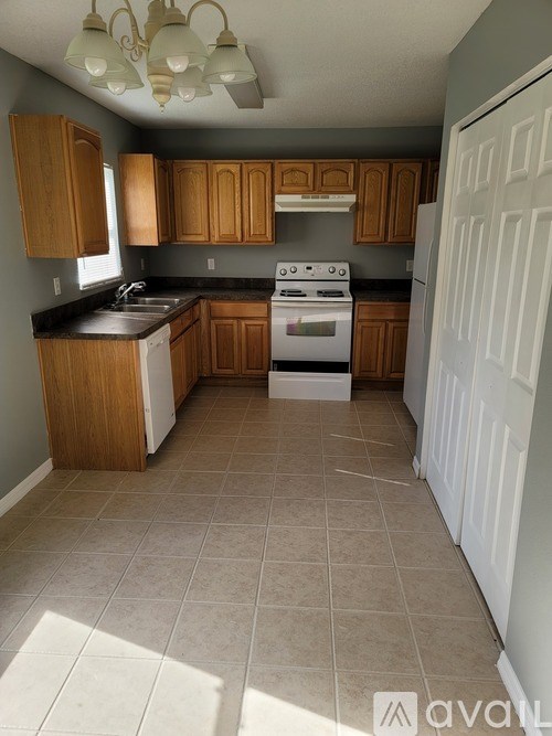 A kitchen with wooden cabinets and a white stove.