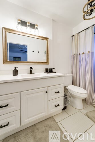 A bathroom with a white toilet, sink, and mirror.