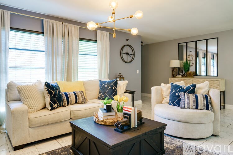 A living room with two couches, a coffee table, and a chandelier.