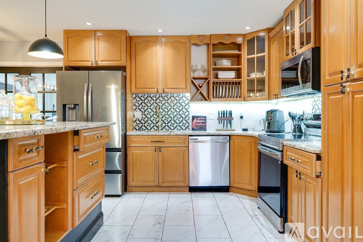 A kitchen with wooden cabinets and a marble countertop.