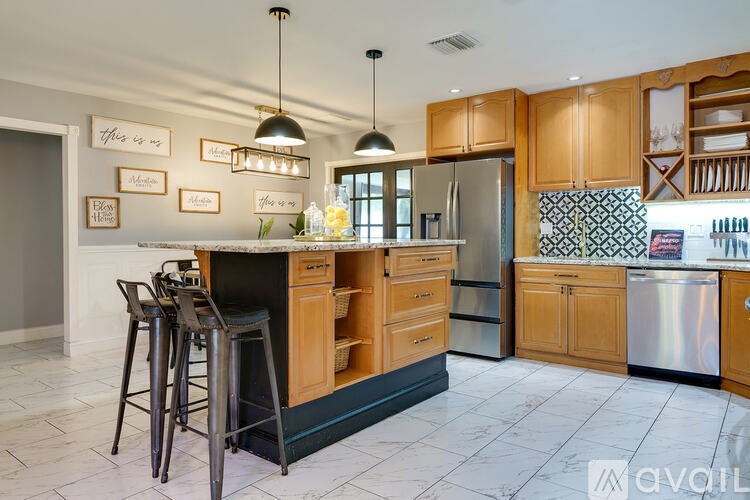 A kitchen with wooden cabinets and a black and white tiled backsplash.