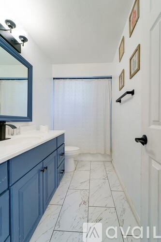A bathroom with blue cabinets and a white sink.