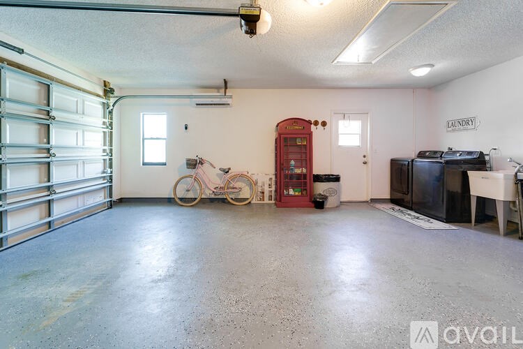 A room with a bicycle and a washing machine.