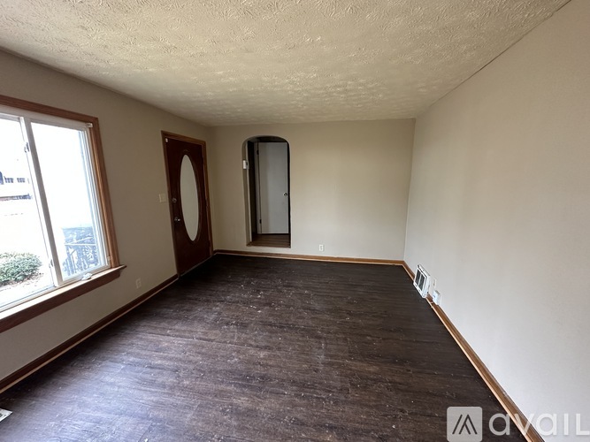 A room with wooden flooring and a large mirror on the wall.