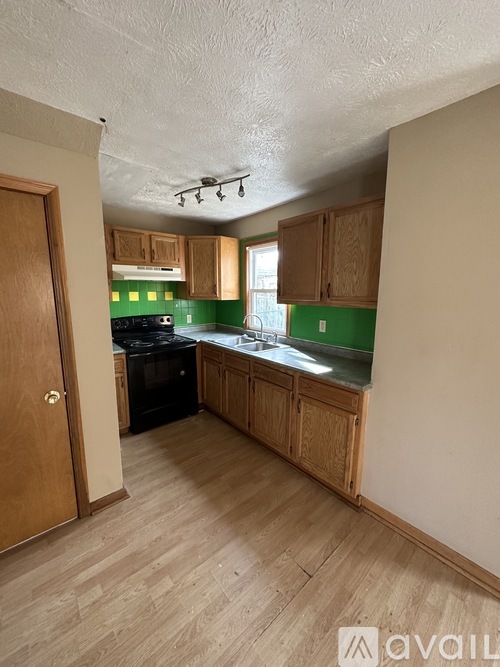 A kitchen with wooden cabinets and a black stove top oven.