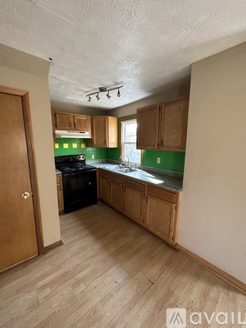 A kitchen with wooden cabinets and a black stove top oven.