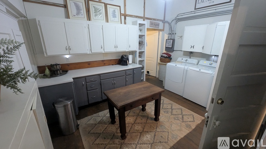 A kitchen with white cabinets and a wooden table.