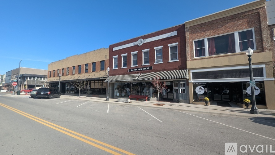 A street view with a building that has a sign that says "AVAIL".