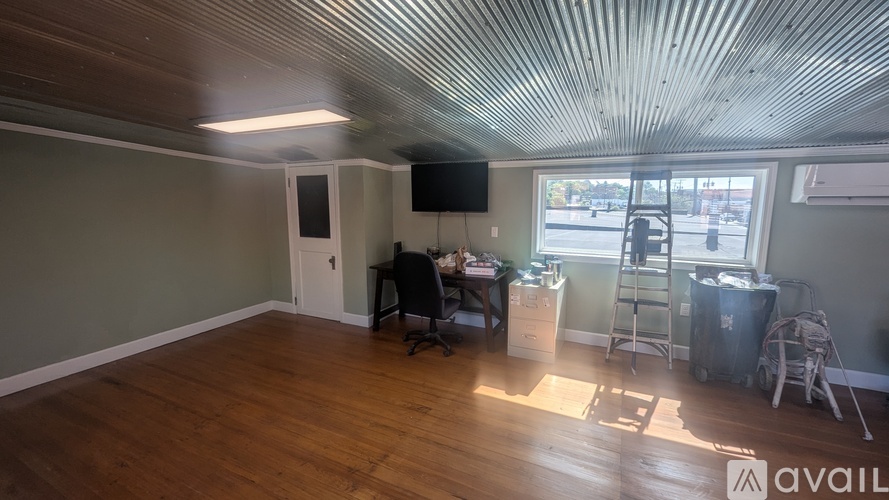 A room with wooden floors and a ceiling with a corrugated texture.