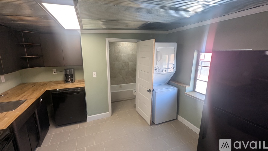 A kitchen with a black fridge and a black dishwasher.