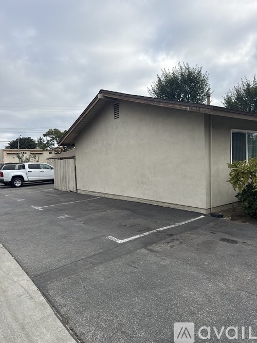 A parking lot with a building and a car.