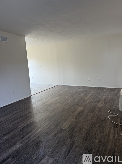 A room with wooden flooring and white walls.