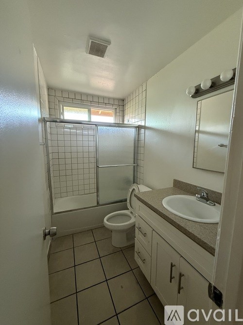 A bathroom with a toilet, sink, and shower.