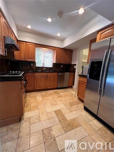 A kitchen with wooden cabinets and a tiled floor.