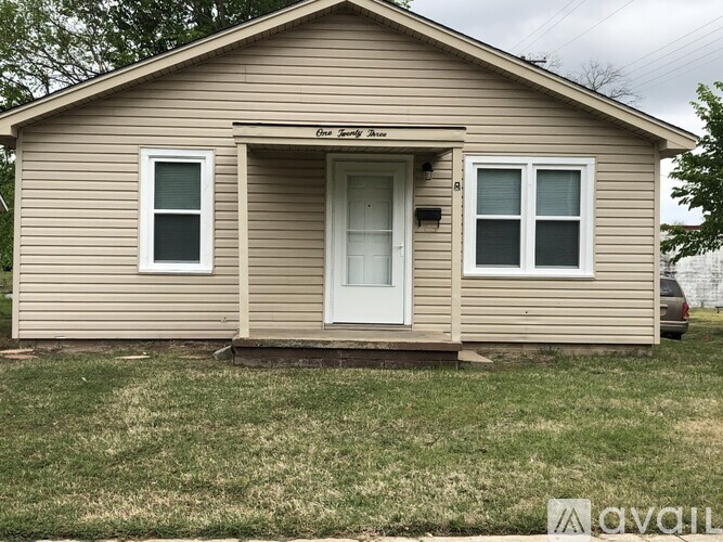 A small house with a brown siding and a white door.
