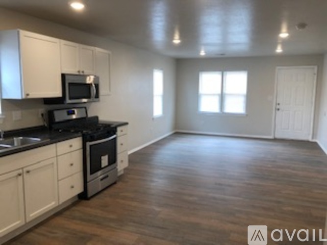 A kitchen with white cabinets and a black counter top.