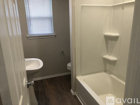 A white bathroom with a tub, sink and toilet.