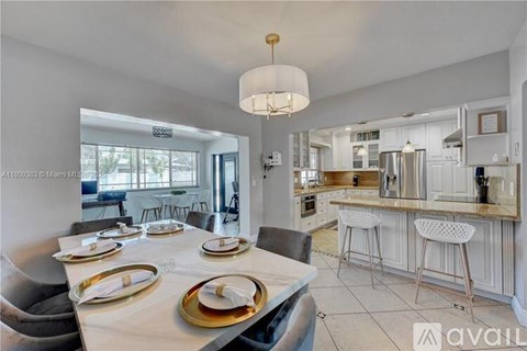 A modern kitchen with a dining table set for four.
