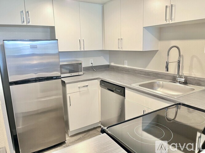 A kitchen with a stainless steel refrigerator, microwave, dishwasher, and oven.
