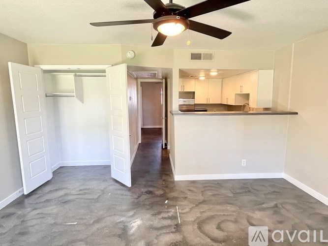 A room with a ceiling fan and a doorway leading to another room.