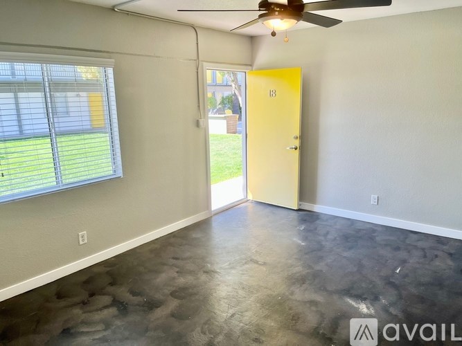 A room with a ceiling fan and a door leading to a balcony.