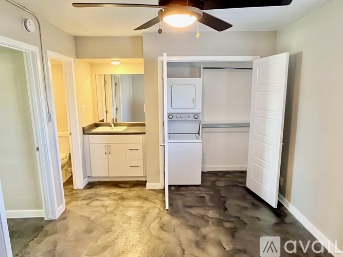 A small, clean, and well-lit kitchen with a refrigerator, sink, and cabinets.