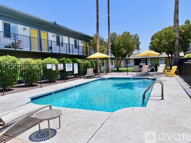 A pool surrounded by a fence and chairs.