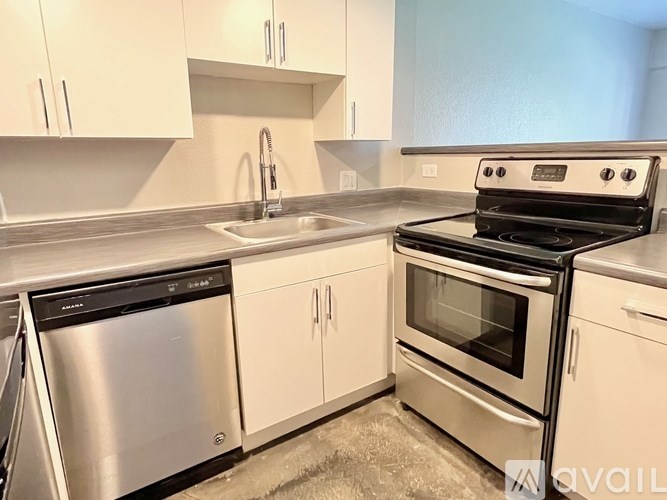 A modern kitchen with a stainless steel dishwasher and oven.