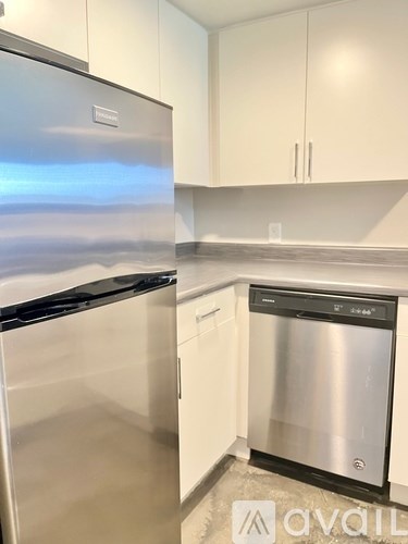 A kitchen with a stainless steel refrigerator and a dishwasher.
