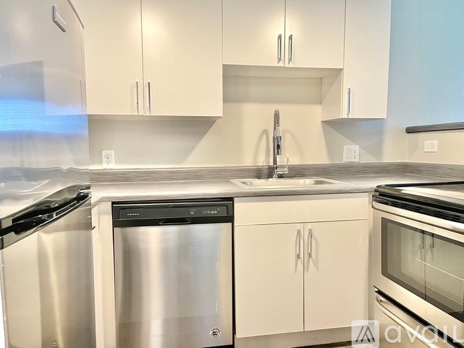 A modern kitchen with stainless steel appliances and white cabinets.