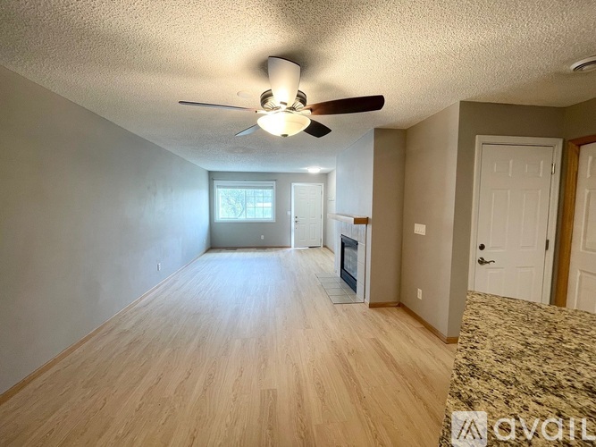 A living room with a ceiling fan and hardwood floors.