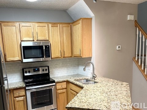 A kitchen with wooden cabinets and granite countertops.