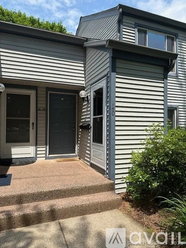 A house with a grey siding exterior and a black door.