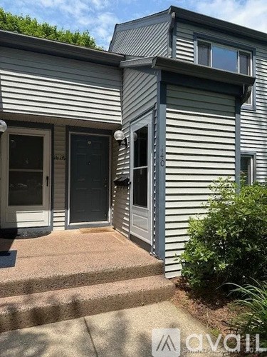 A house with a grey siding exterior and a black door.