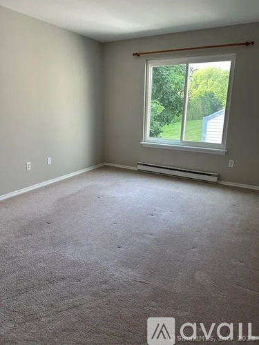 A room with a carpeted floor and a window.
