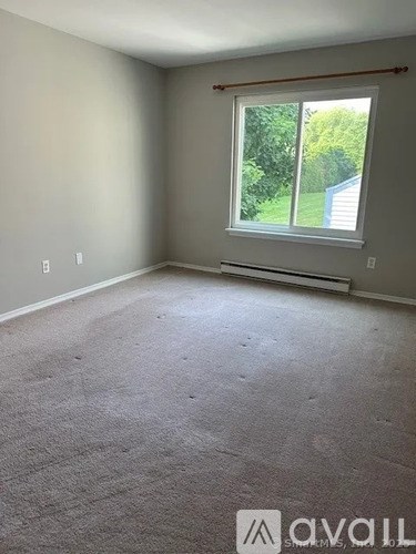 A room with a carpeted floor and a window.