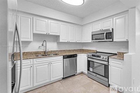 A kitchen with white cabinets and a black stove top oven.