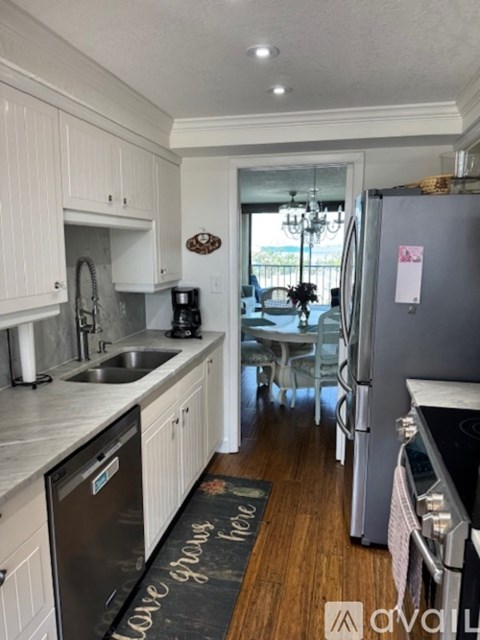 A kitchen with white cabinets and a black fridge.