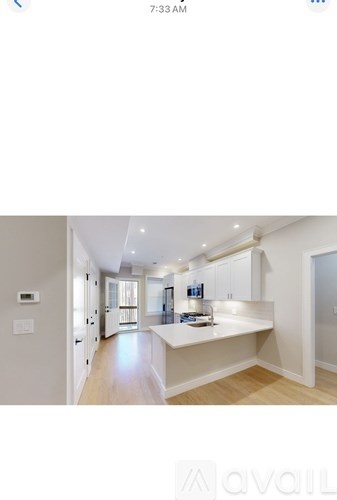 A modern kitchen with white cabinets and a large island.