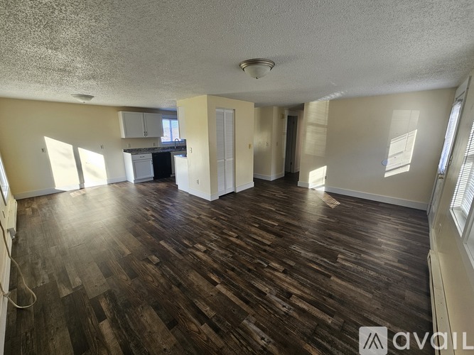 A house with a balcony and two trash bins in front.