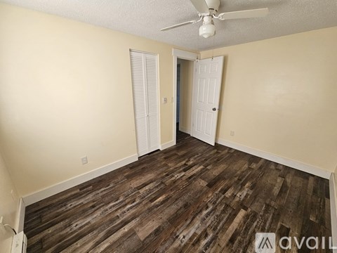 A room with a wooden floor and a ceiling fan.