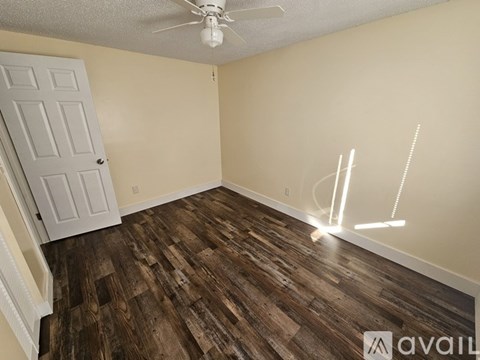 A room with wooden flooring and a white door.