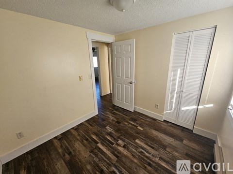 A room with wooden flooring and a white door.