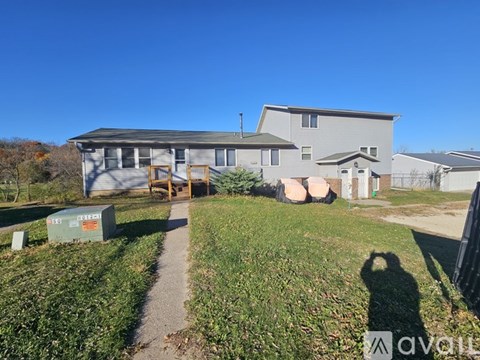 A house with a grey roof and a green lawn in front.