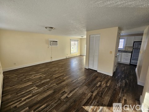A room with wooden flooring and a window.